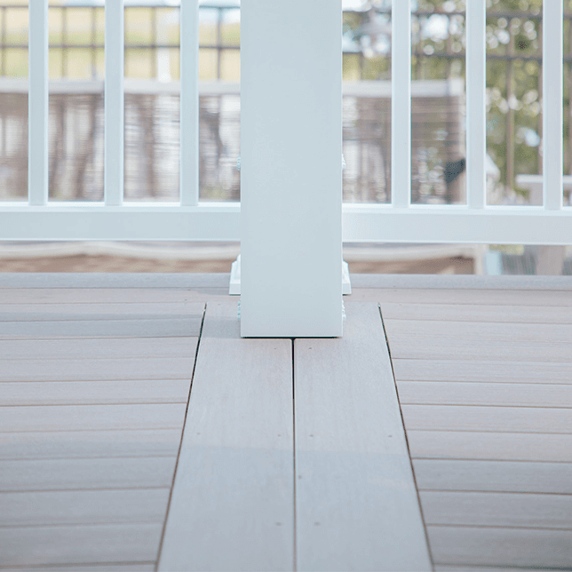 A close-up view of modern white blinds installed on a ceiling window, filtering sunlight to create a soft and serene indoor atmosphere. The blinds are slightly tilted to allow a controlled amount of natural light to enter the room.