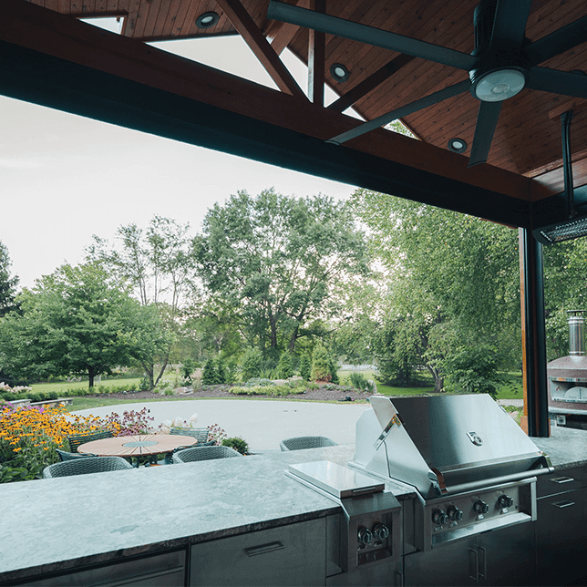 View of a house featuring intricate wooden architecture with exposed beams under the eaves and a clear sky in the background, highlighting modern cabin design and construction details.