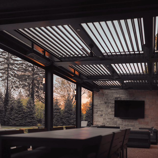 A sleek modern ceiling fan is mounted on the ceiling, with blades partially silhouetted against a geometric pattern of parallel lines created by illuminated panels above. The fan casts soft shadows, adding to the minimalist aesthetic of the space.