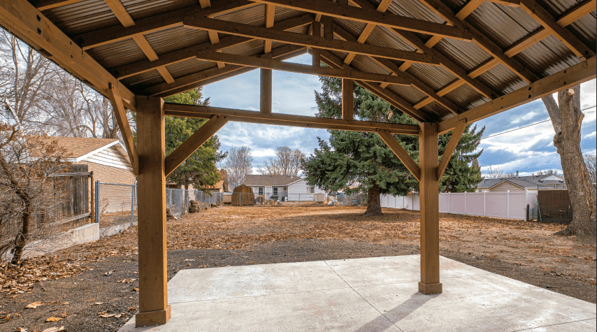 A close-up view of a striped retractable awning attached to a modern building, illustrating the awning's texture and mechanism against a clear blue sky.