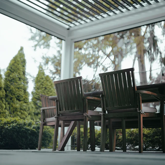 Close-up view of modern white blinds with a blurred natural background visible through the slats, emphasizing a sleek and clean design suitable for contemporary interiors.